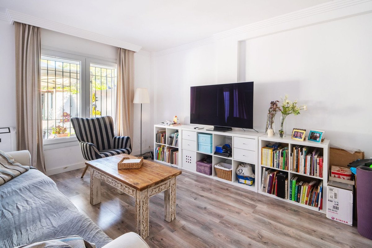 Modern living room with large window, striped chair, wooden table, and bookshelves