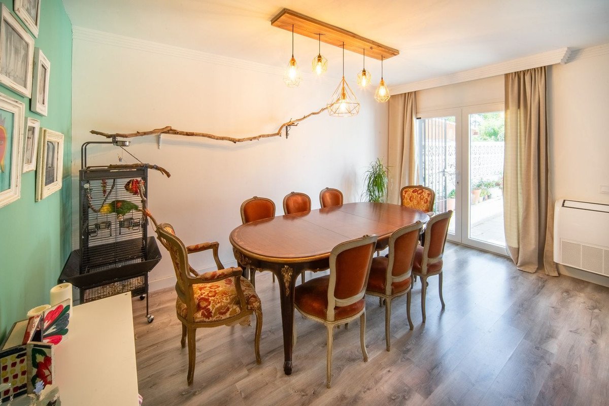 Elegant dining room with a large wooden table, upholstered chairs, and natural light from sliding doors