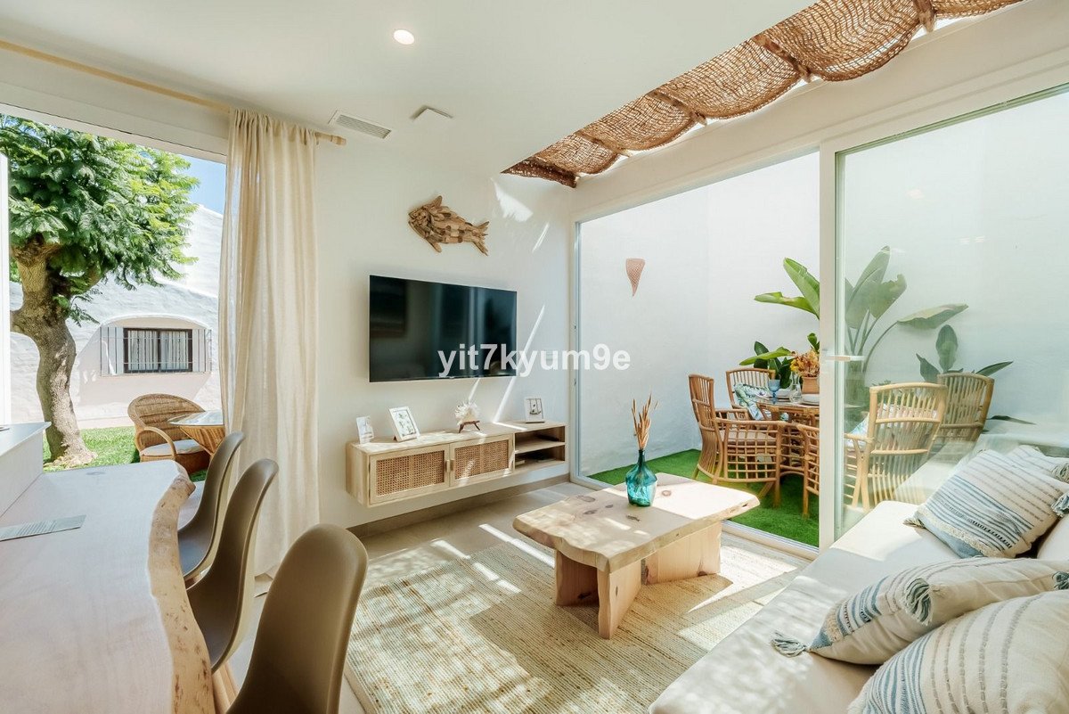 Modern living room with large windows, beige furniture, and a view of the garden