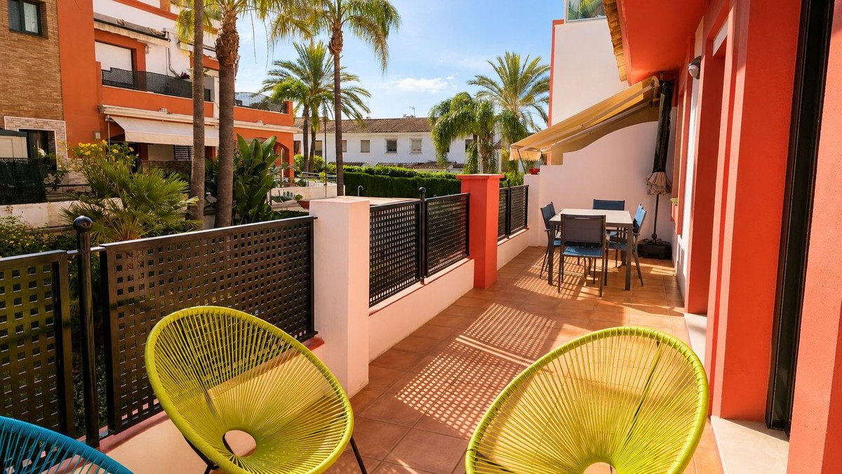 Terrace with yellow chairs, palm trees, and outdoor dining area