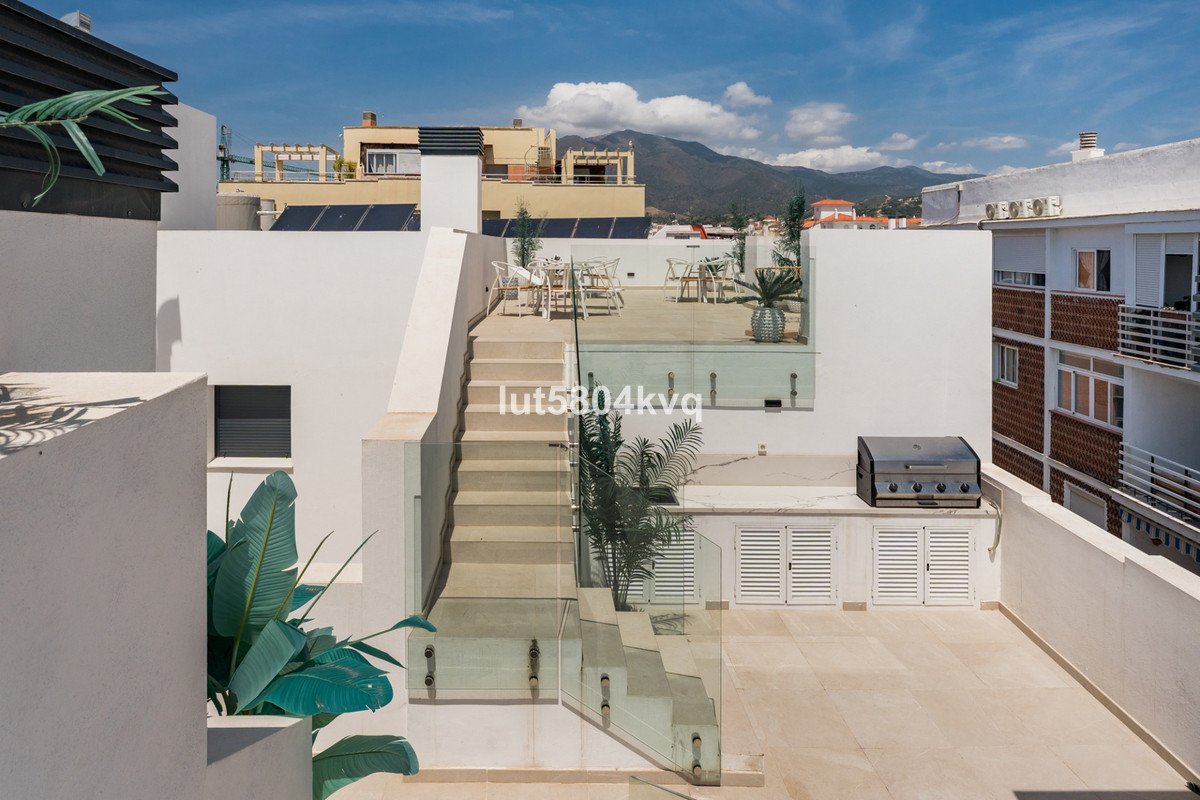 Modern white rooftop terrace with outdoor seating and mountain view