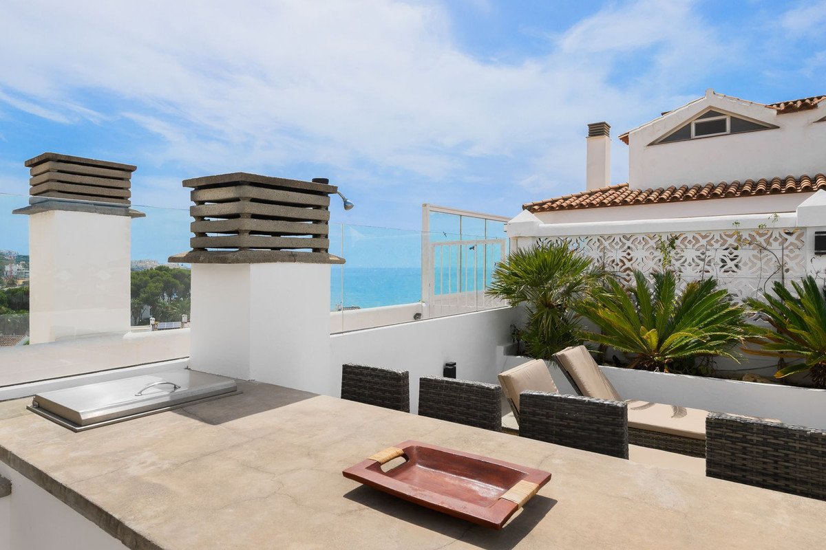 Modern white rooftop terrace with sea view and outdoor seating