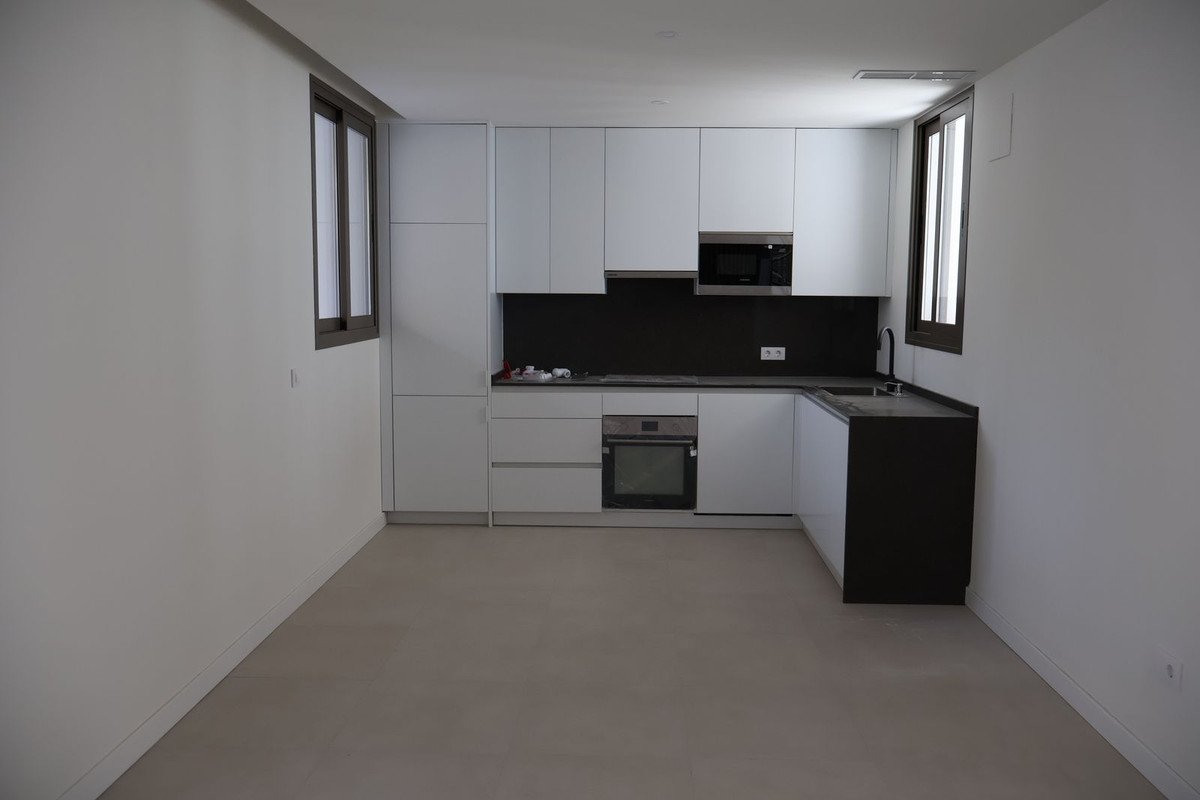 Modern minimalist kitchen with white cabinets and black countertops