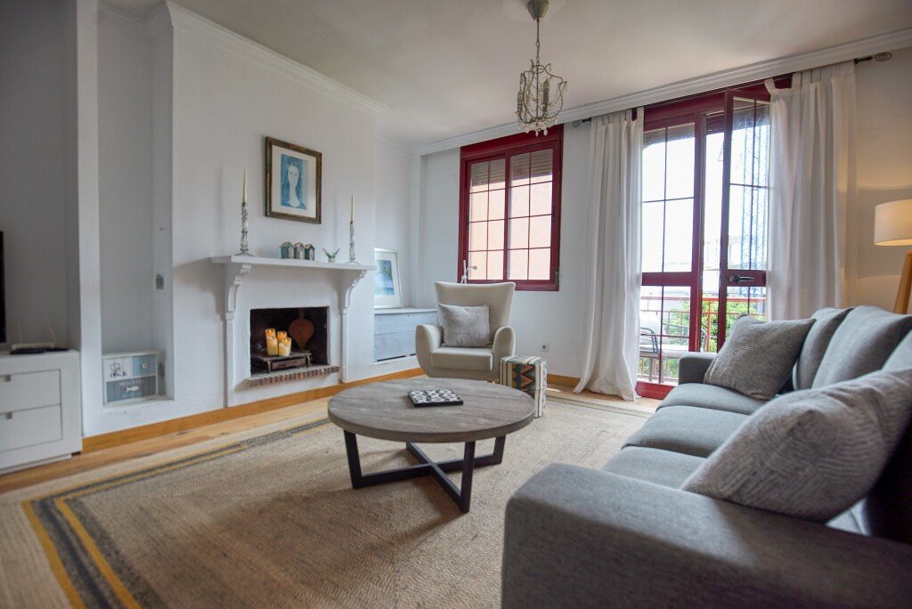 Cozy living room with fireplace, large windows, and modern furniture