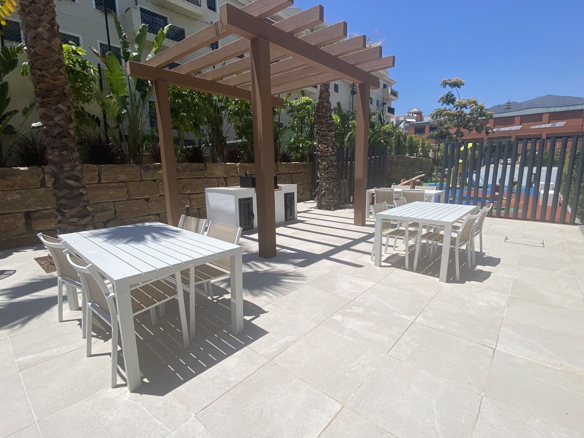 Patio with tables and pool in background, sunny outdoor area