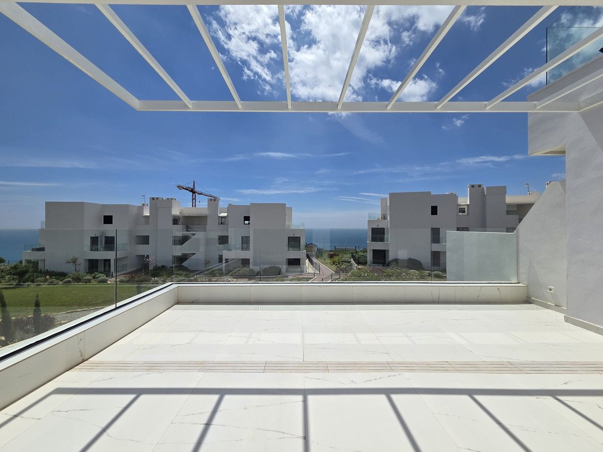 Modern white apartment complex with sea view and clear blue sky
