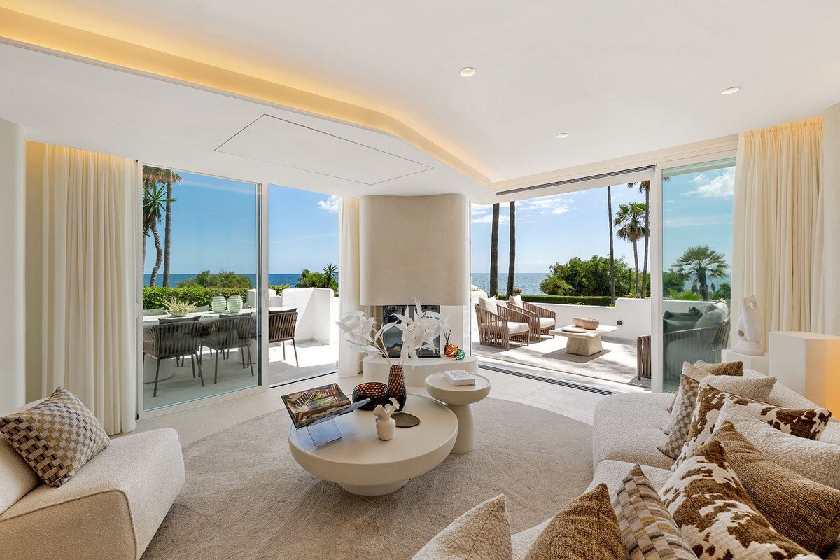 Modern living room with large windows overlooking the ocean and palm trees
