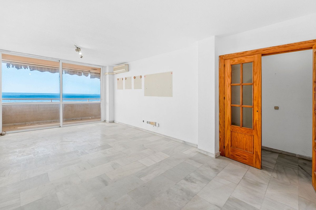 Spacious room with sea view through large window and wooden door