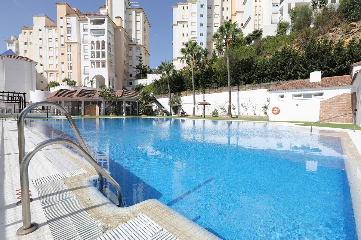 Swimming pool with clear blue water and luxury apartments in the background