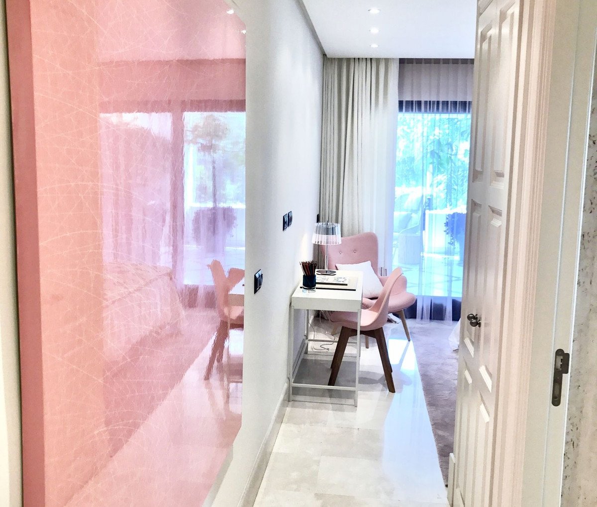 Modern living room with pink accent wall and large windows