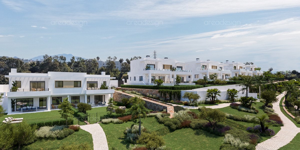 Row of modern white villas with balconies and green landscaped gardens, overlooking mountains.