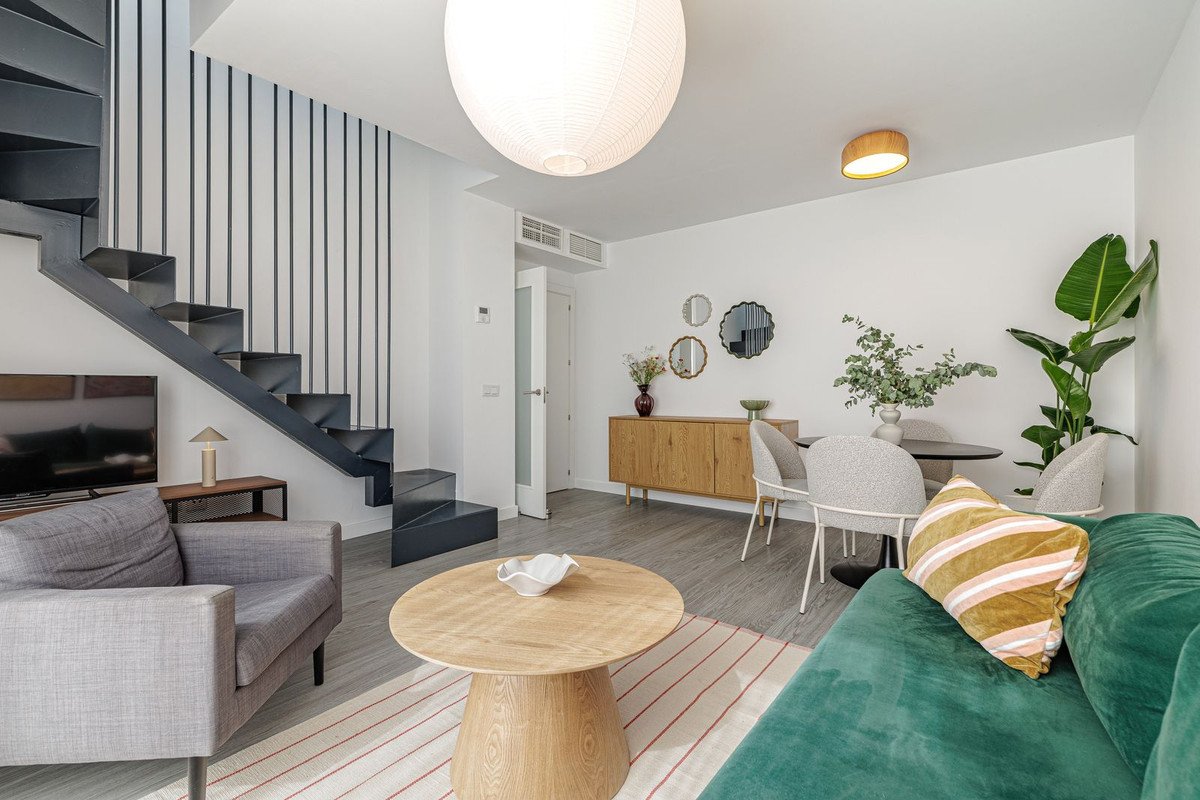 Modern living room with grey sofa, wooden coffee table, and minimalist staircase