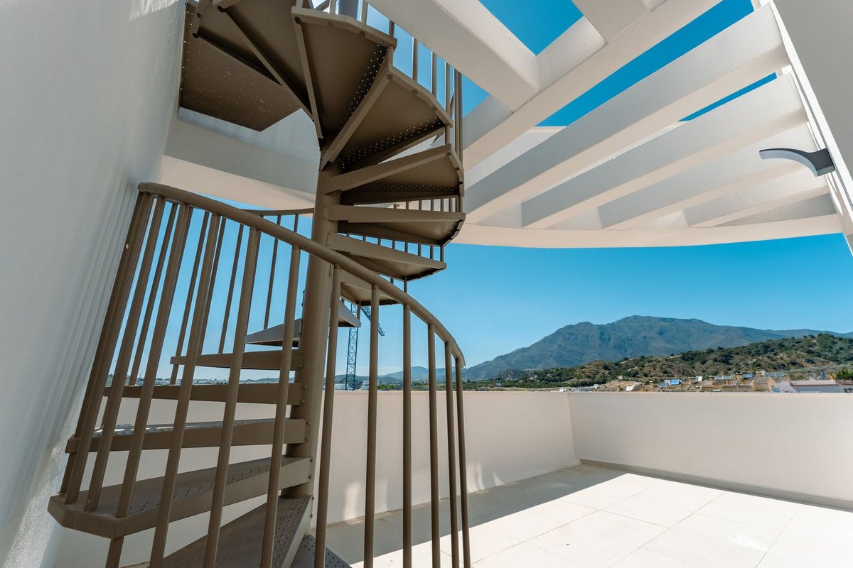 Modern spiral staircase with a view of mountains and clear blue sky