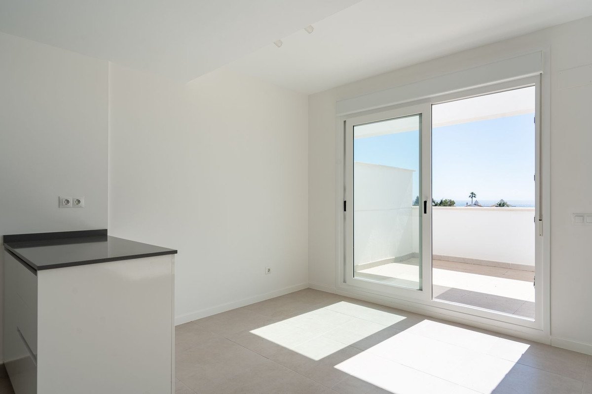 Modern interior with a sliding glass door opening to a balcony with a beautiful sea view.