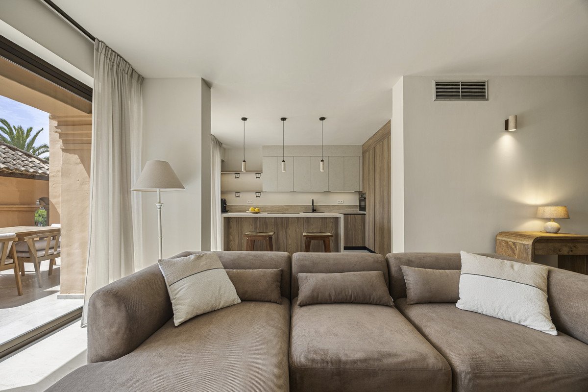 Modern living room with large sectional sofa and kitchen view