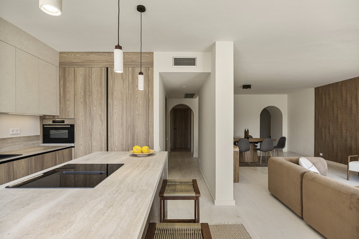 Modern open-plan living space with kitchen, dining area, and neutral tones
