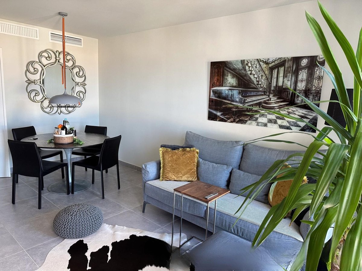 Modern living room featuring a gray sofa, wooden coffee table, and a large framed artwork on the wall