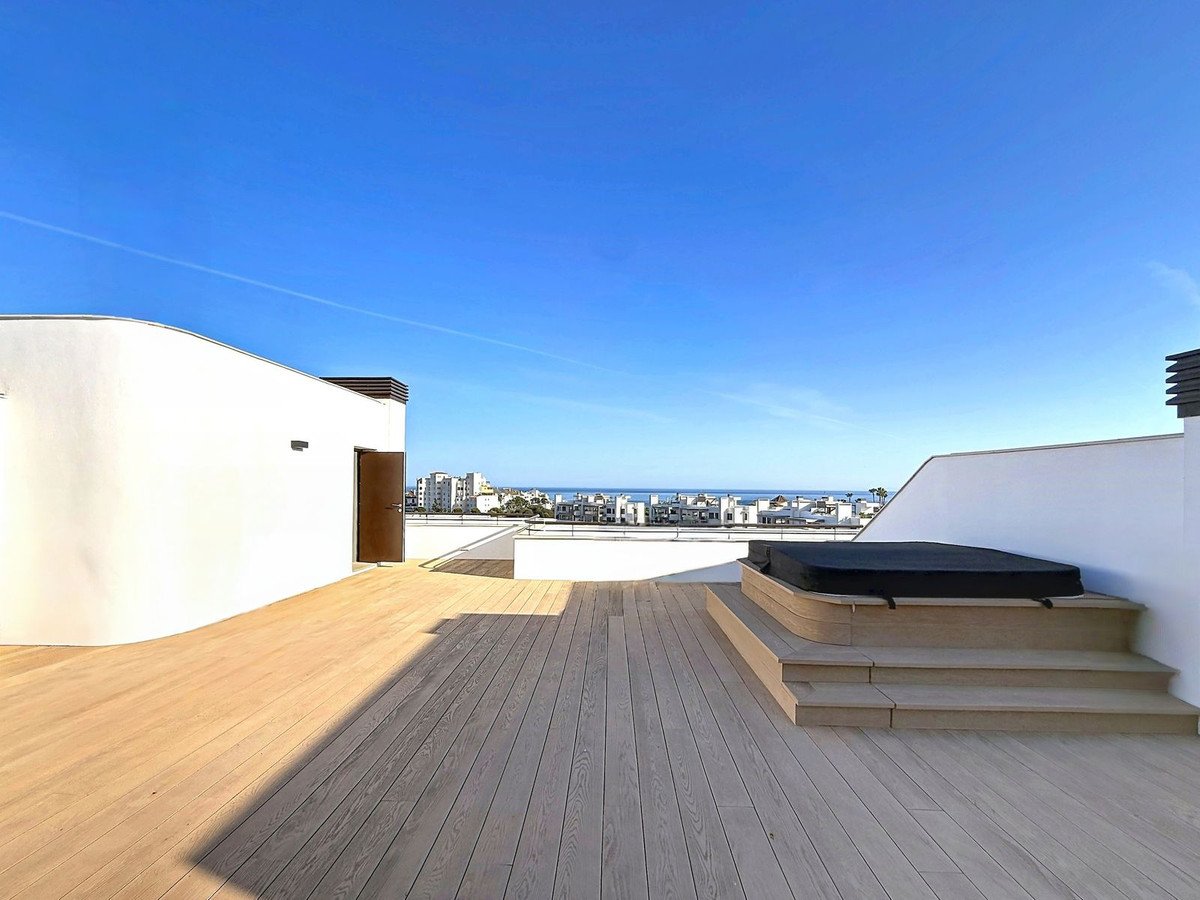 Modern white patio with wooden flooring and ocean view
