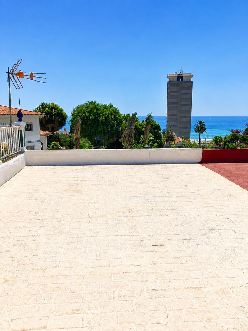 Terrace with sea view and tall building in the background