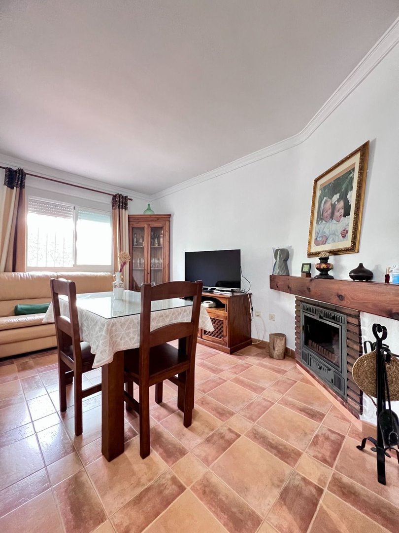 Living room with dining table, fireplace, and large window view