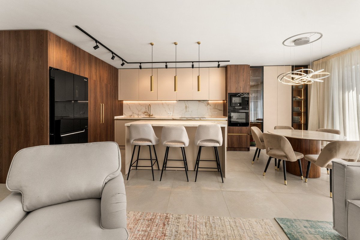 Modern open-plan living dining kitchen with neutral tones and contemporary furniture