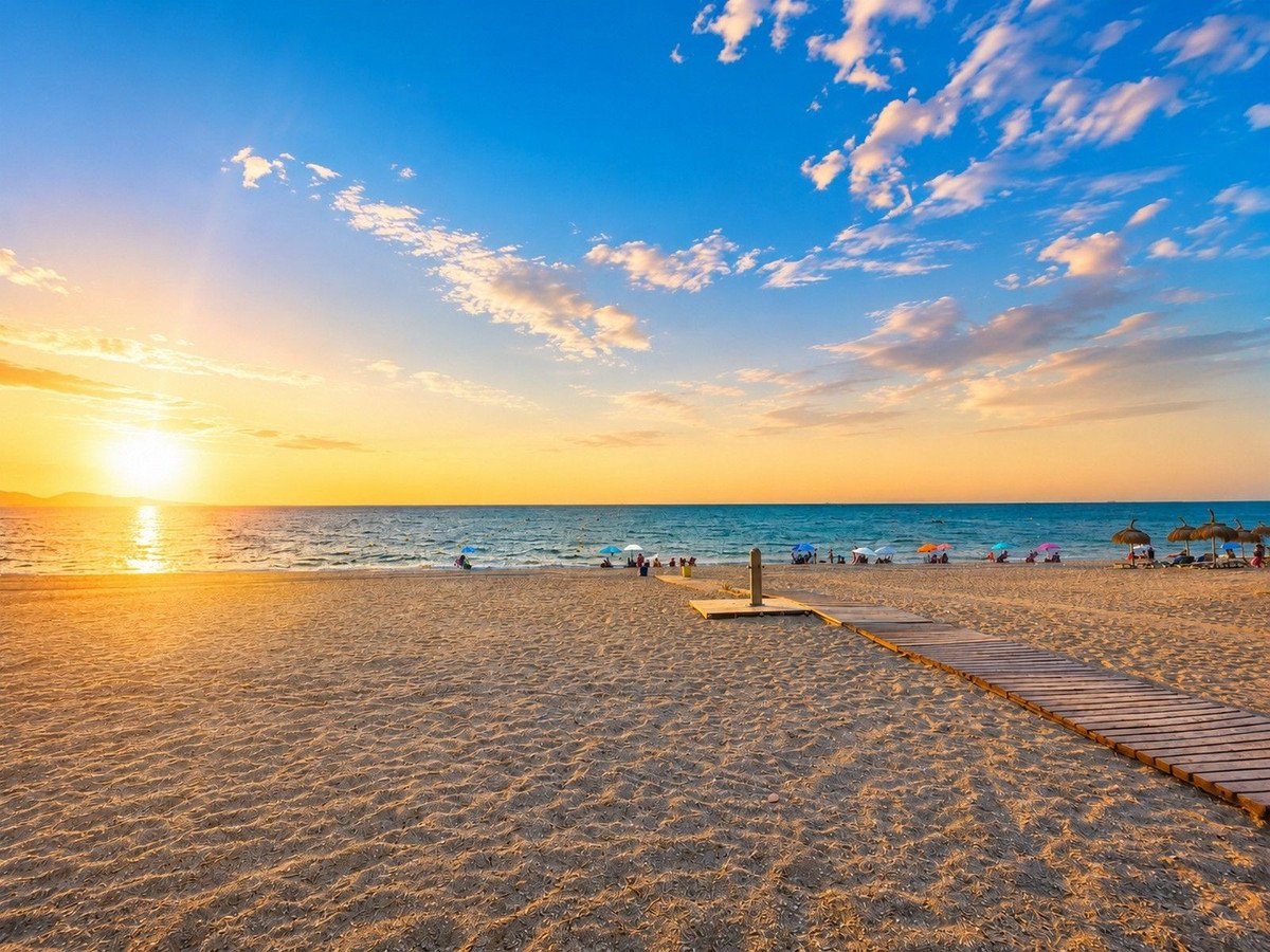 Sunset beach view with lounge areas and wooden walkway