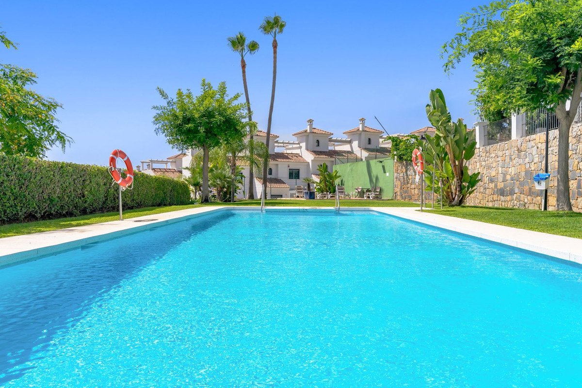 Villa with private pool, palm trees, and Mediterranean-style architecture under clear blue sky.