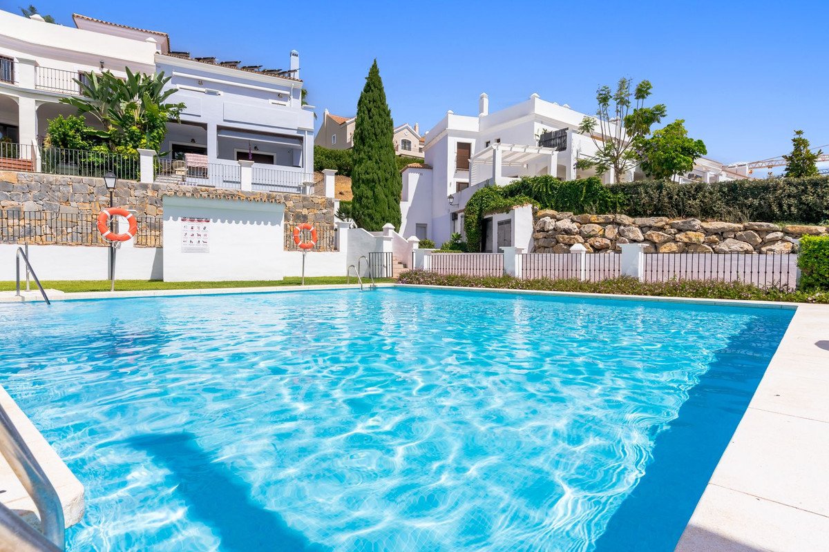 Villa with private pool, white Mediterranean-style buildings, and lush greenery under a clear blue sky.