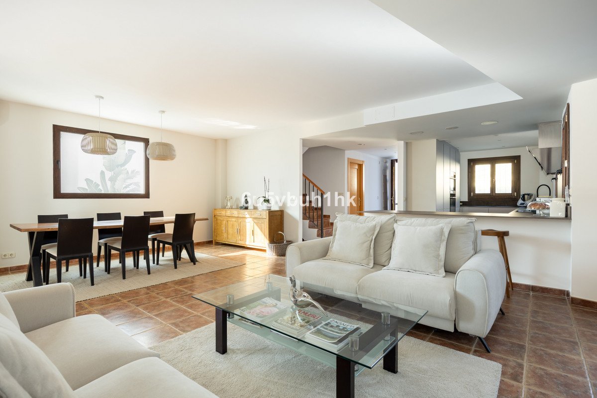 Spacious open-plan living and dining area with modern furniture and a view into the kitchen.