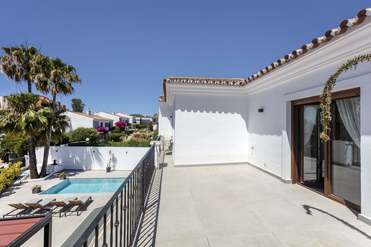 White house with tiled roof and swimming pool in sunny outdoor area