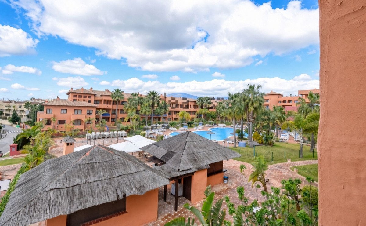 Apartment view with swimming pool and palm trees in resort complex