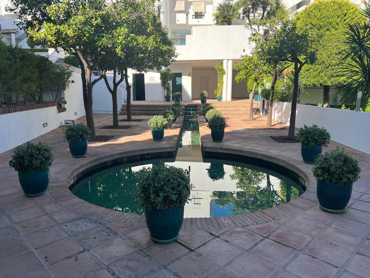 Courtyard with round pool, potted plants, and tiled patio area