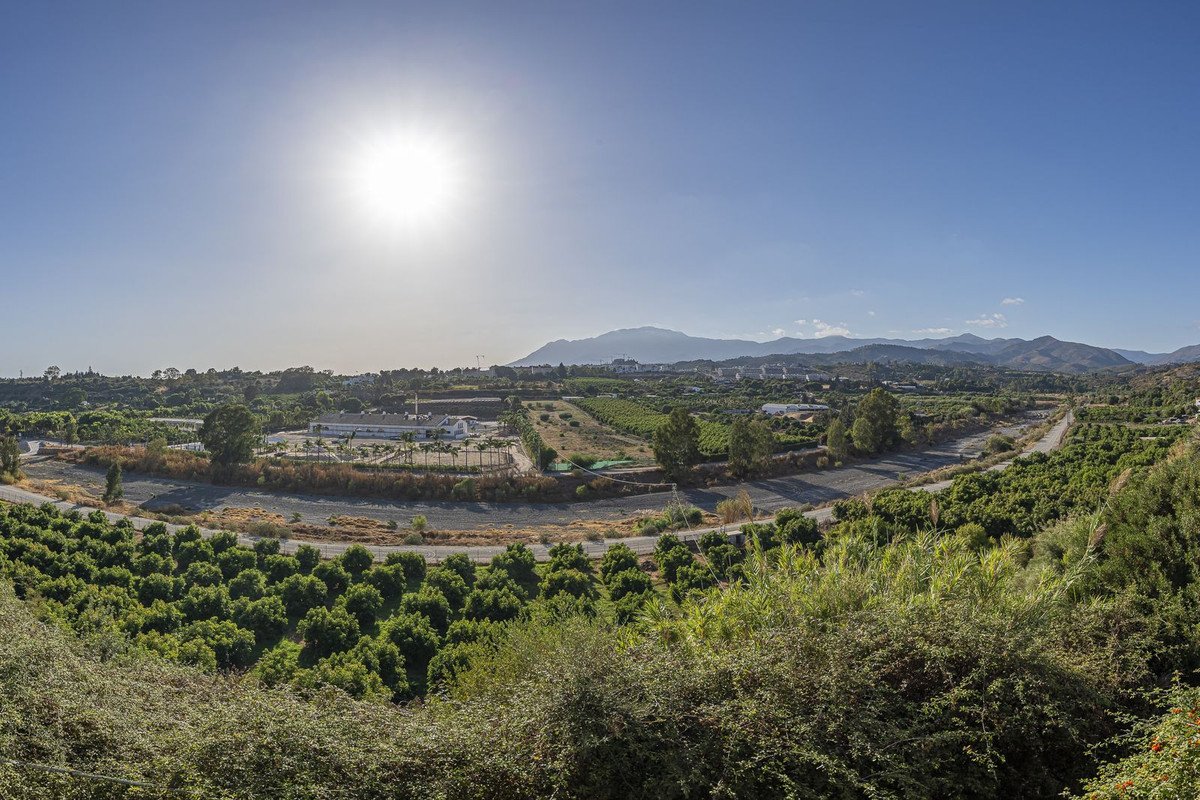 Panoramic view of mountains and fields under bright sun