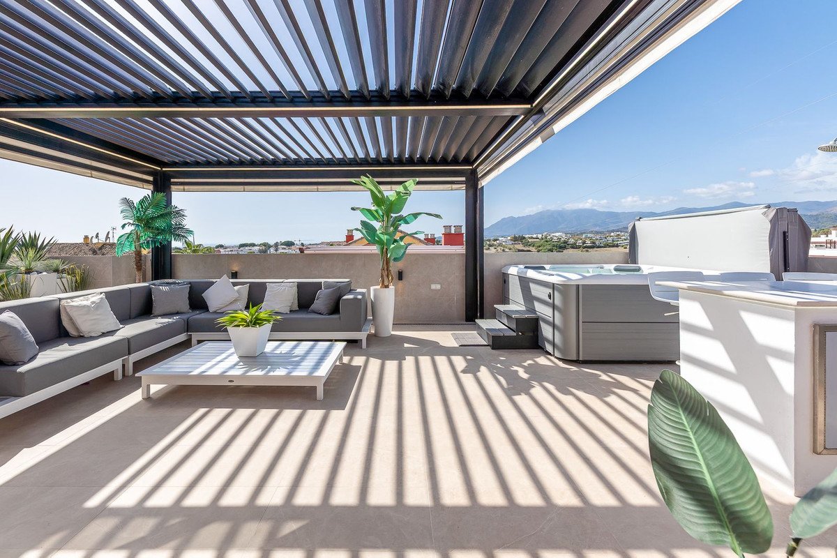 Rooftop terrace with outdoor seating, hot tub, and mountain views