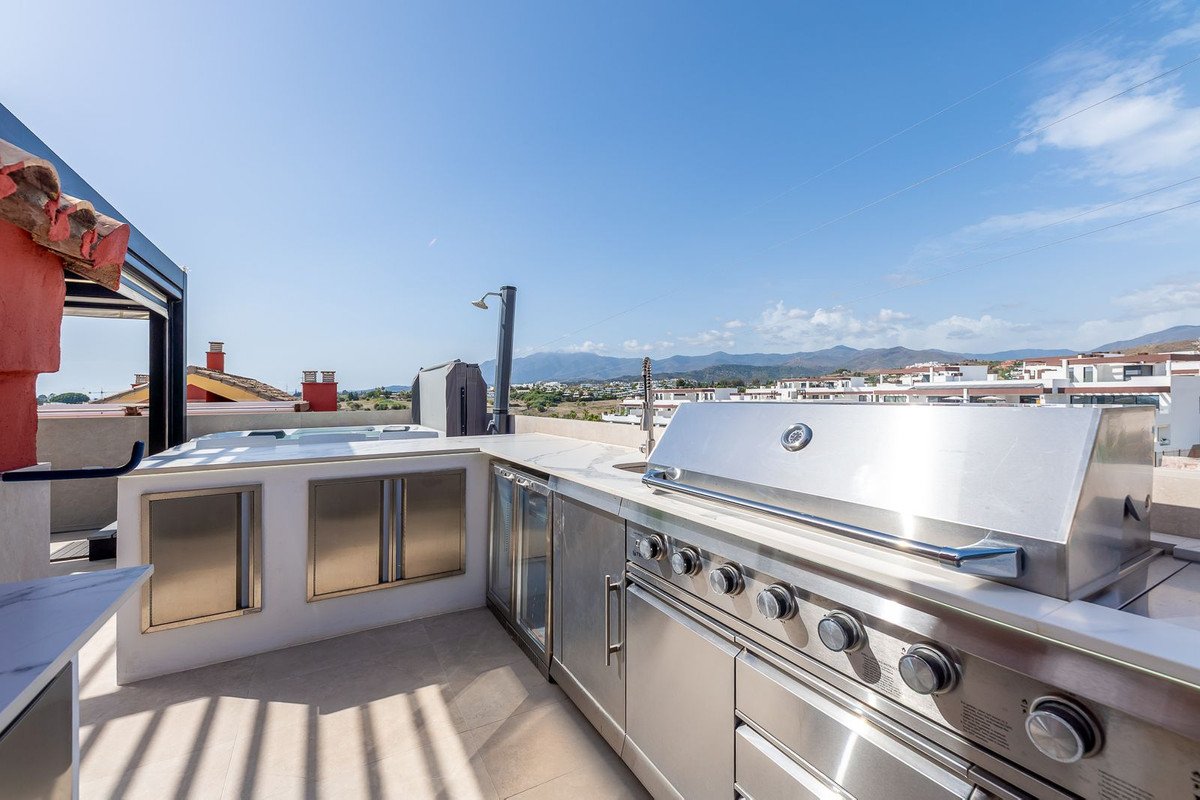 Rooftop outdoor kitchen with stainless steel appliances and mountain views