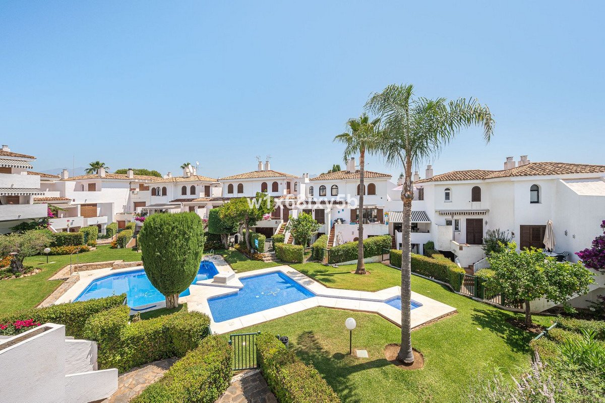White townhouses with a shared swimming pool and landscaped garden