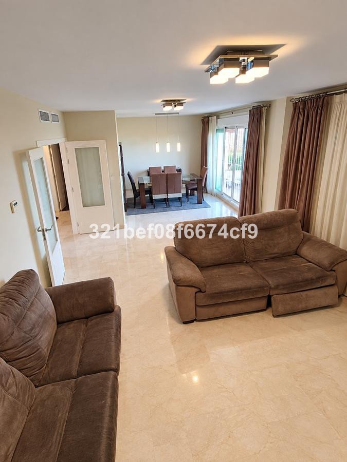 Spacious living and dining area with modern furniture, large windows, and comfortable seating.