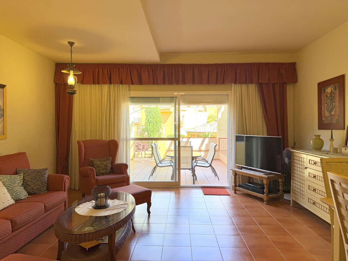 Cozy living room with tile floor, large window, and outdoor seating area