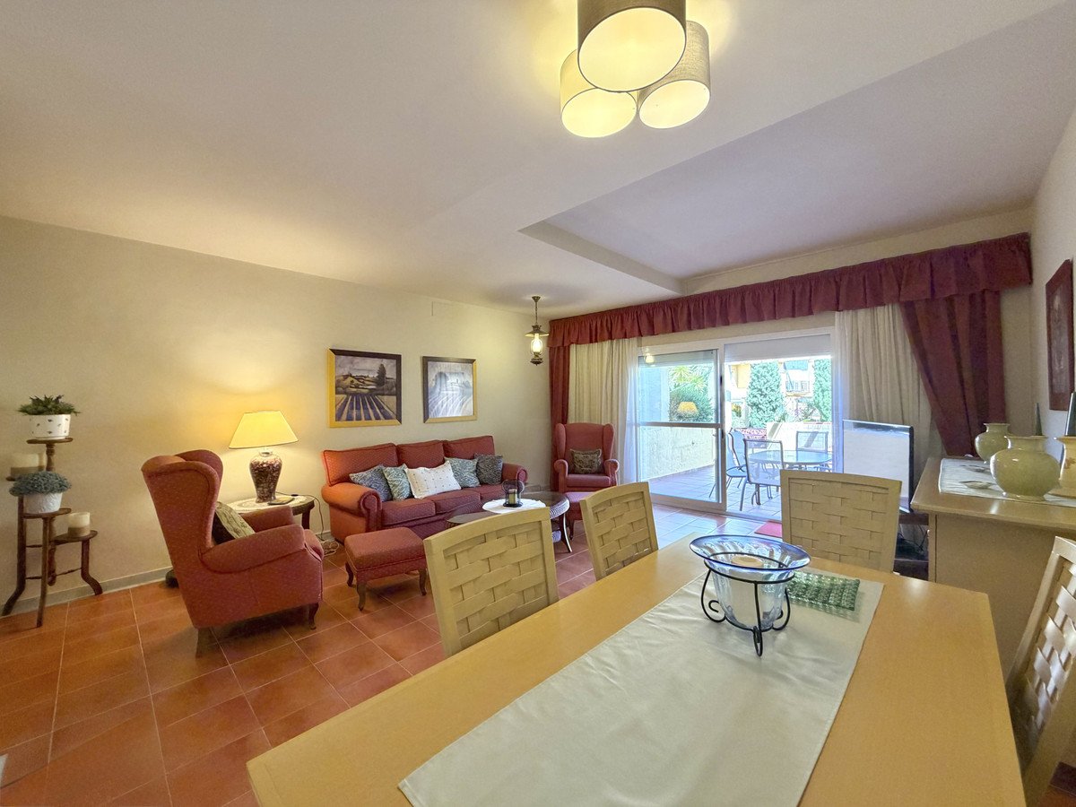 Cozy living room with red furniture, dining table, and balcony view