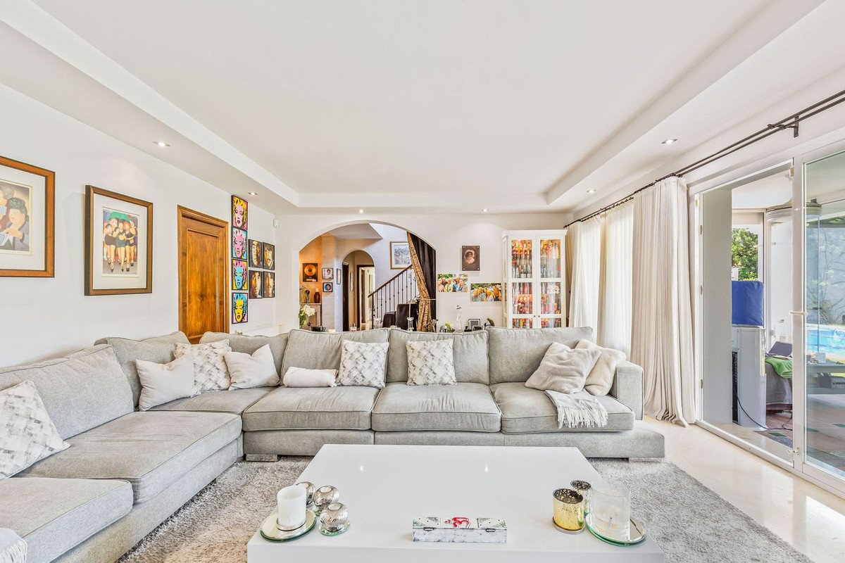 Spacious living room with a large grey sectional sofa, white coffee table, and sliding glass doors opening to a pool area.
