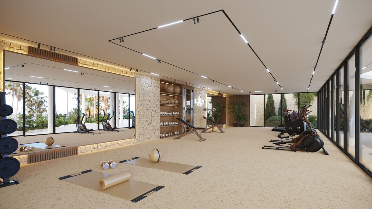 Moderne fitnessruimte in Altezza Suites met gewichten, cardio-apparatuur en yogamatten.