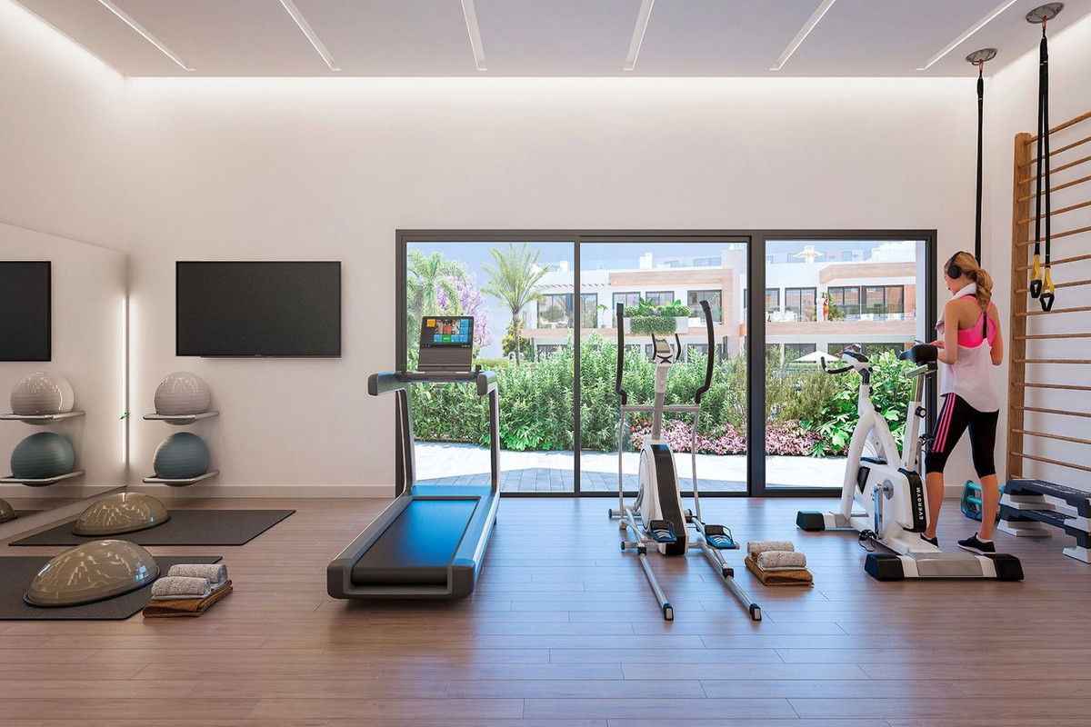 Moderne gymzaal in Atalaya Emotions met fitnessapparatuur en uitzicht op de tuin.