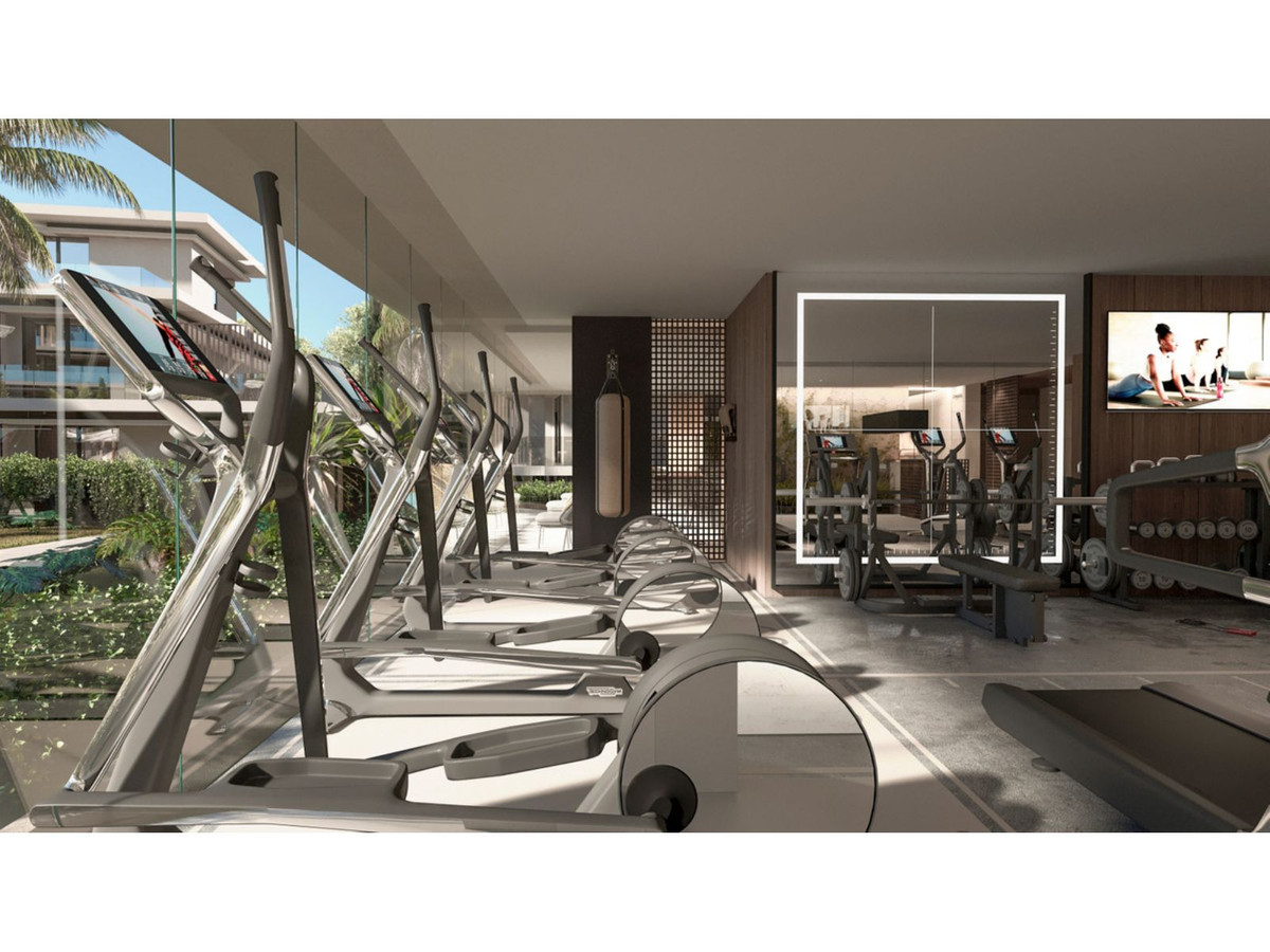 Moderne residentie fitnessruimte met cardio- en krachtapparatuur.