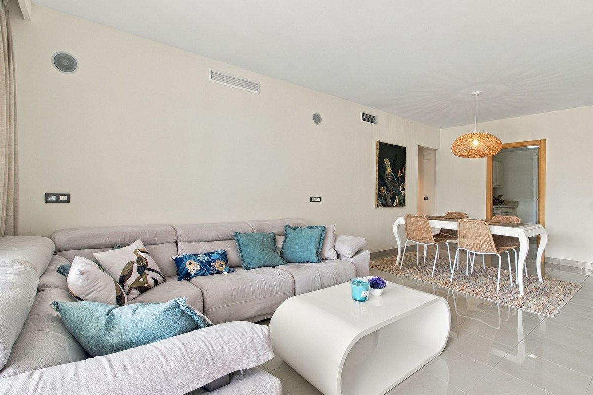 A modern living and dining area with a large sectional sofa, a white coffee table, and a dining table with four chairs.