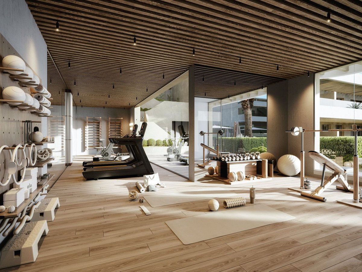 Modern gym with treadmills, free weights, yoga mats, and fitness equipment, featuring wooden accents and natural light.