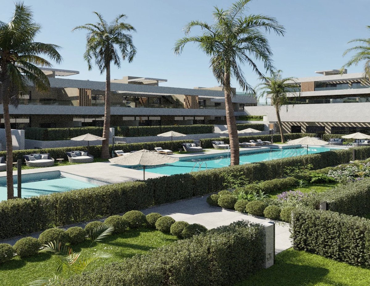 Modern apartment complex with swimming pools, lounge chairs, umbrellas, lush landscaping, and palm trees.