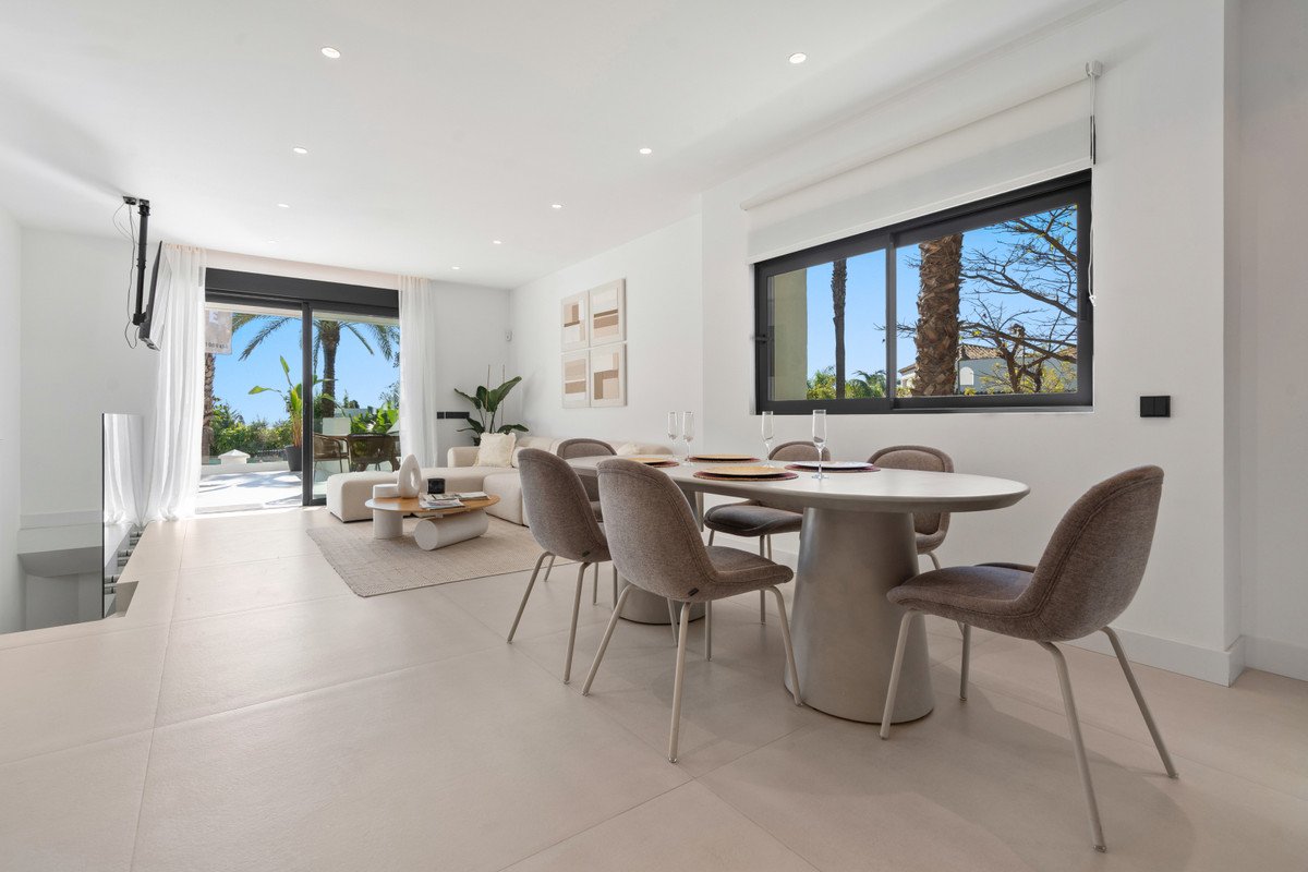 Modern open-plan living and dining room with large windows and outdoor view