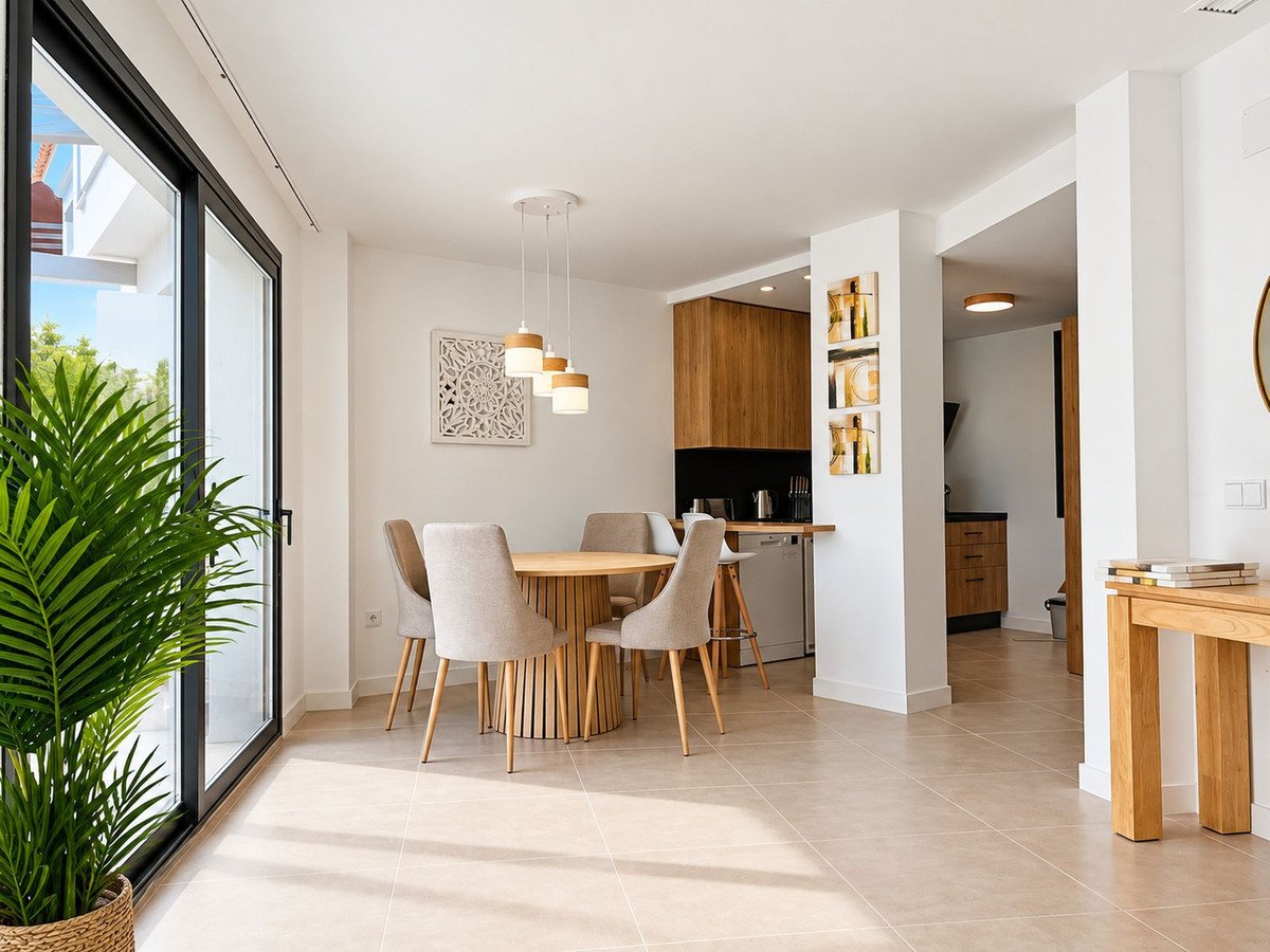 Modern dining room with sliding glass doors, wooden table, and pendant lights.