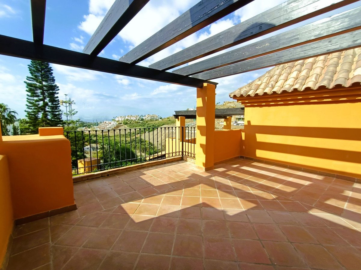 A spacious terrace with tiled flooring, a pergola, and scenic views of the landscape.