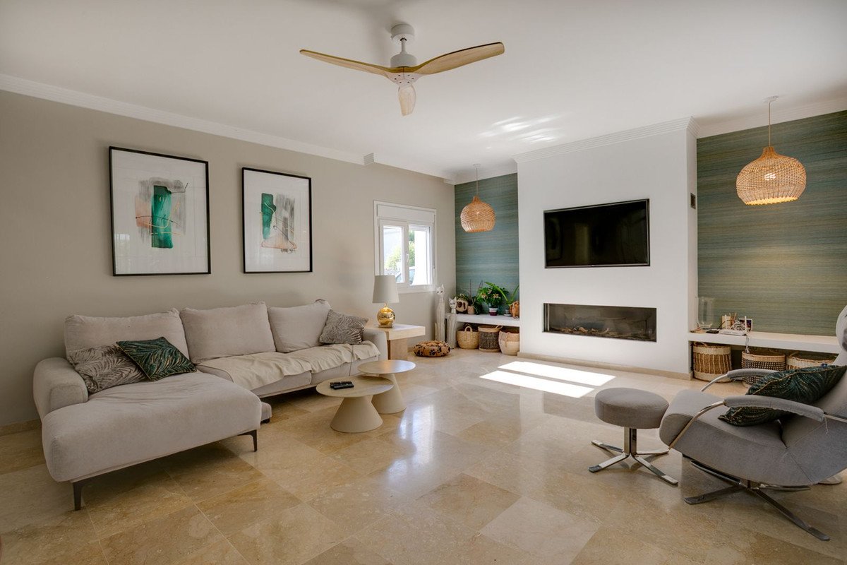Modern living room with a comfortable sofa, contemporary fireplace, mounted TV, and decorative artwork on the wall.